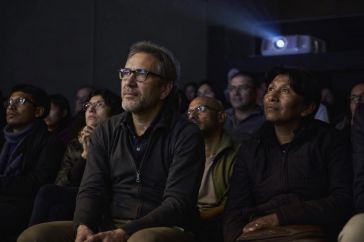 Josep Guirau presenta su documental sobre derechos humanos ante un público diverso en sala oscura y atenta.