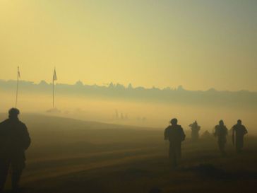 En el campo de batalla de Soledar, Ucrania, una niebla fría cubre el terreno mientras la lucha continúa. Los soldados rusos y el Grupo Wagner avanzan hacia las líneas ucranianas bajo la luz del sol amarillo.