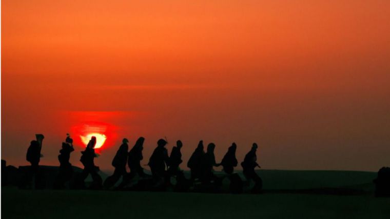 En una ciudad europea, un grupo de soldados se preparan para partir a la guerra contra Rusia. El sol se pone sobre el horizonte, 