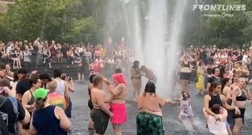 En Nueva York, mujeres en topless juegan con niños en la fiesta acuática del evento del orgullo